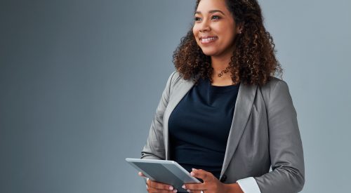 Studio shot of a young businesswoman using a digital tablet against a grey background