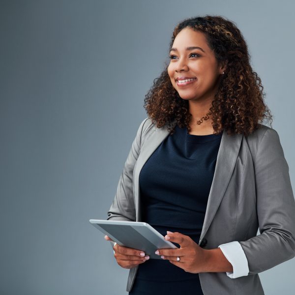 Studio shot of a young businesswoman using a digital tablet against a grey background