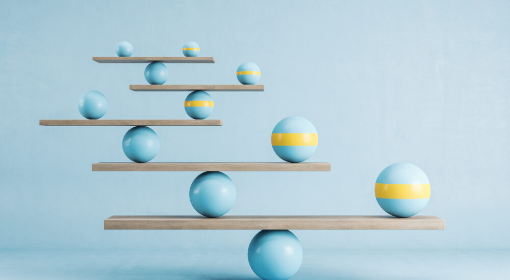 Blue and yellow balls balanced on wooden platforms