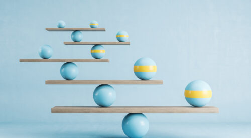 Blue and yellow balls balanced on wooden platforms