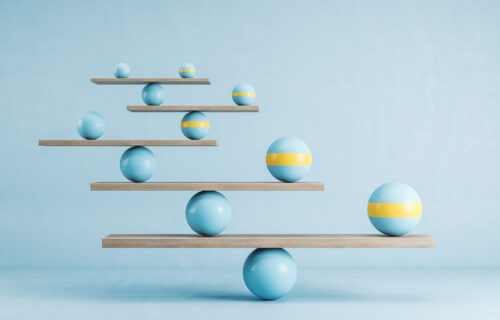 Blue and yellow balls balanced on wooden platforms