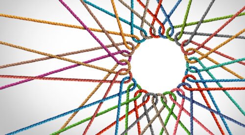 Abstract image showing interconnecting ropes of differing colours on a white/grey background