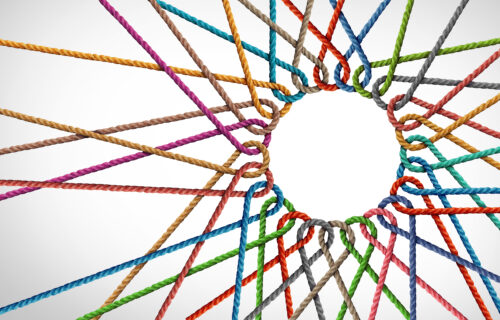 Abstract image showing interconnecting ropes of differing colours on a white/grey background