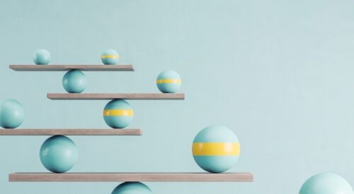 Blue and yellow balls balanced on wooden platforms