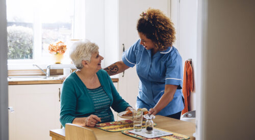 Carer serving meal to a lady