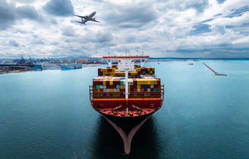 plane logistic and cargo container ship sailing in sea import export goods and distributing products to dealer and consumers across worldwide, by container ship industry